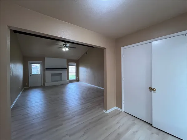 a view of empty room with wooden floor and fireplace