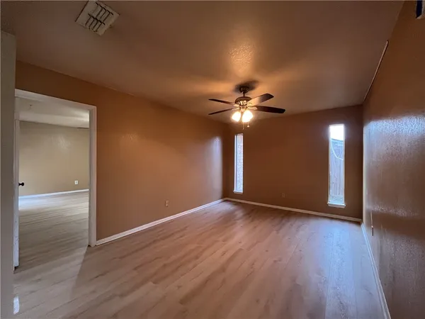 a view of an empty room with wooden floor