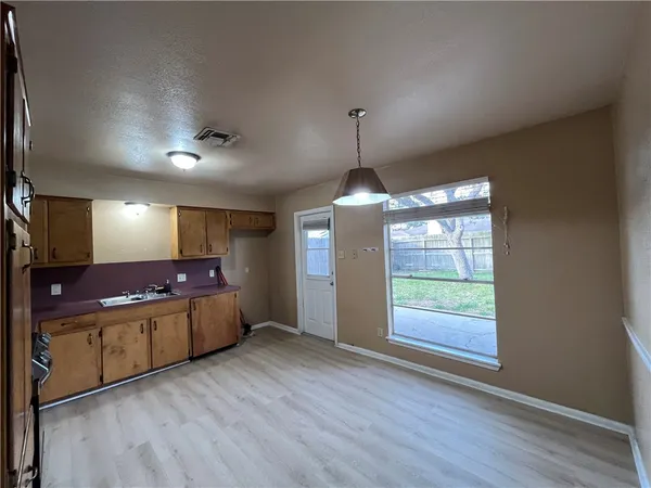 a kitchen with stainless steel appliances granite countertop a sink a stove and a wooden floors