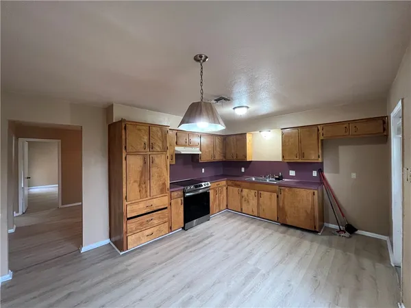 a kitchen with a wooden floor and stainless steel appliances