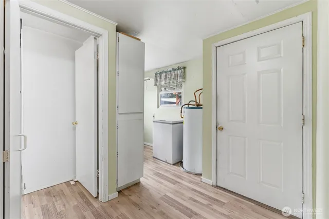 a view of a hallway with wooden floor and closet area