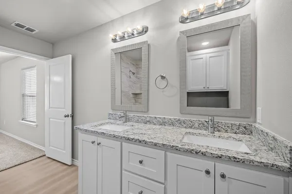 a bathroom with a granite countertop sink and a mirror