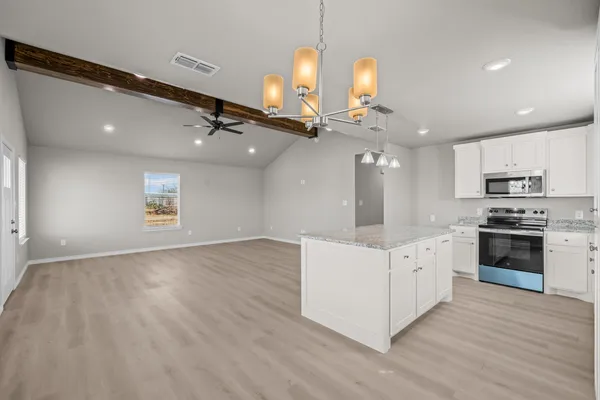 a kitchen with stainless steel appliances granite countertop a stove sink and cabinets