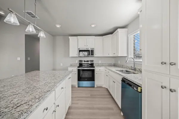 a kitchen with a sink chandelier and a stove