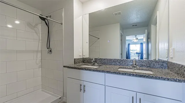 a bathroom with a granite countertop sink and mirror