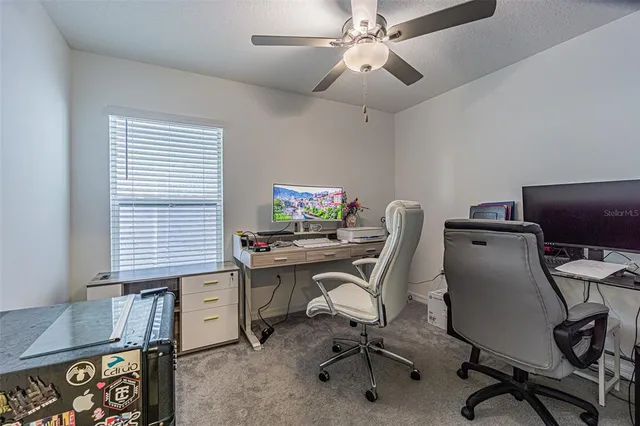 a view of a workspace with furniture and a window