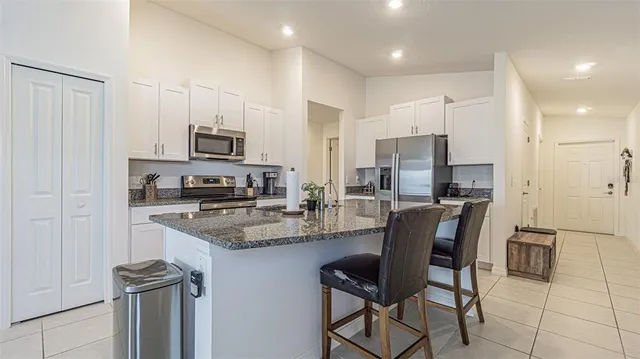 a kitchen with kitchen island granite countertop wooden cabinets and stainless steel appliances