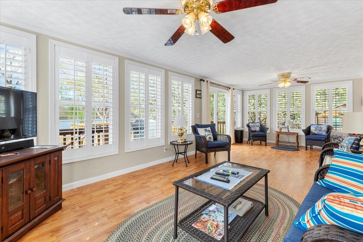 3729 Clark Road Hiwassee, VA 24347 - Photo 27 of 52 a living room with furniture a flat screen tv and a floor to ceiling window