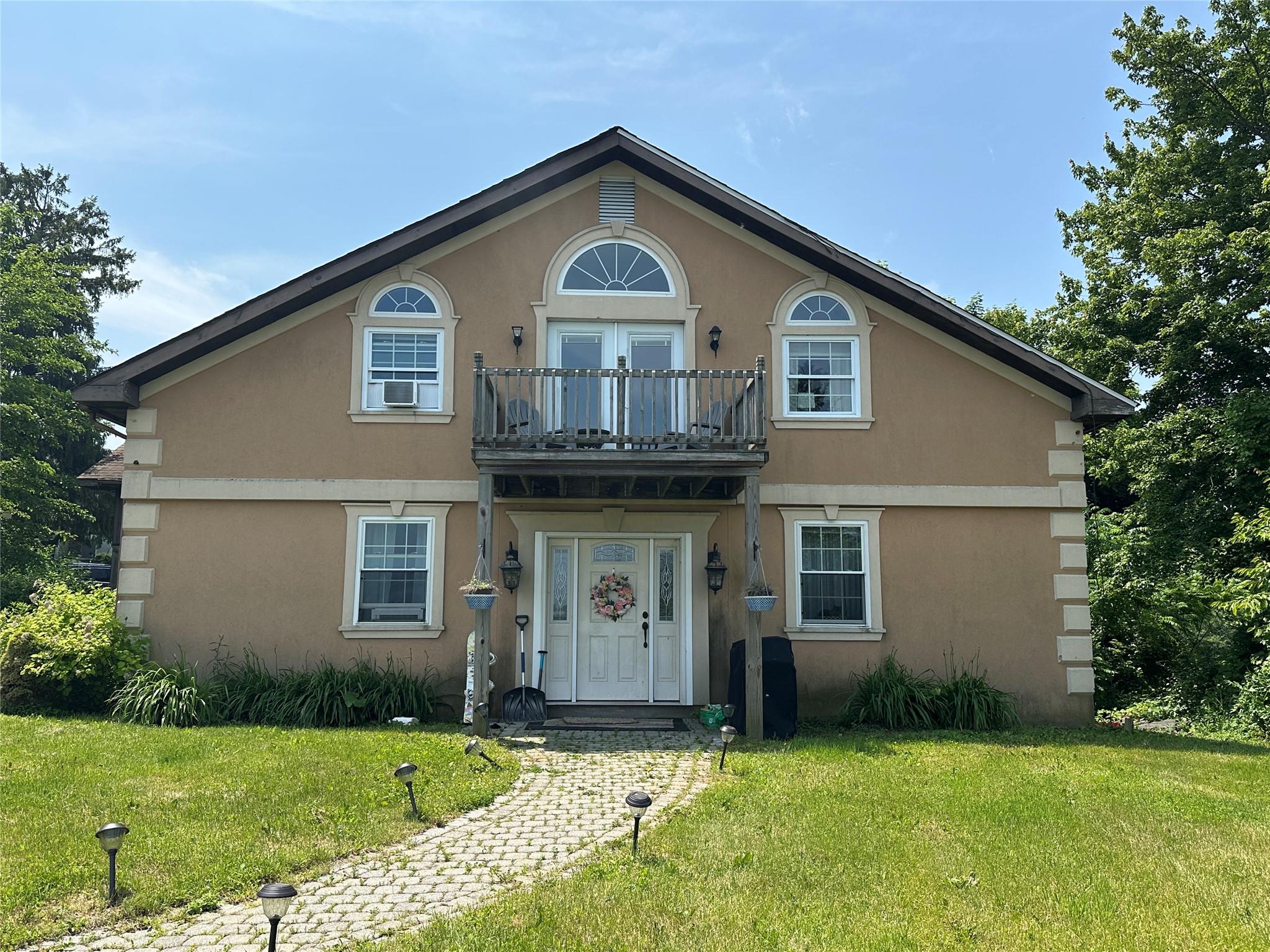 a front view of a house with a garden and yard