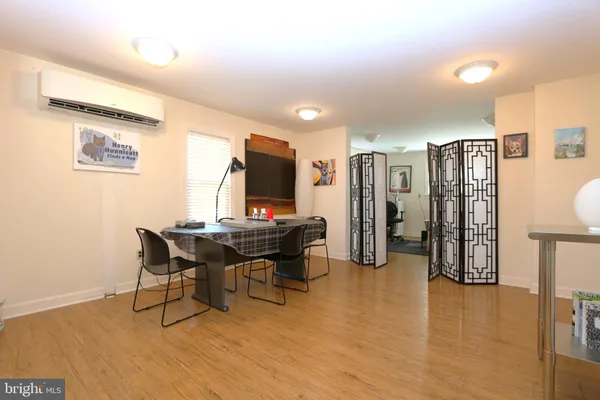 a living room with dining table and wooden floor