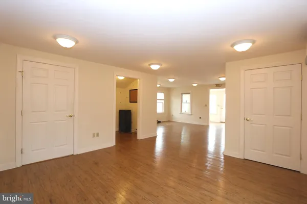 a living room with furniture and a dining table with bookshelf