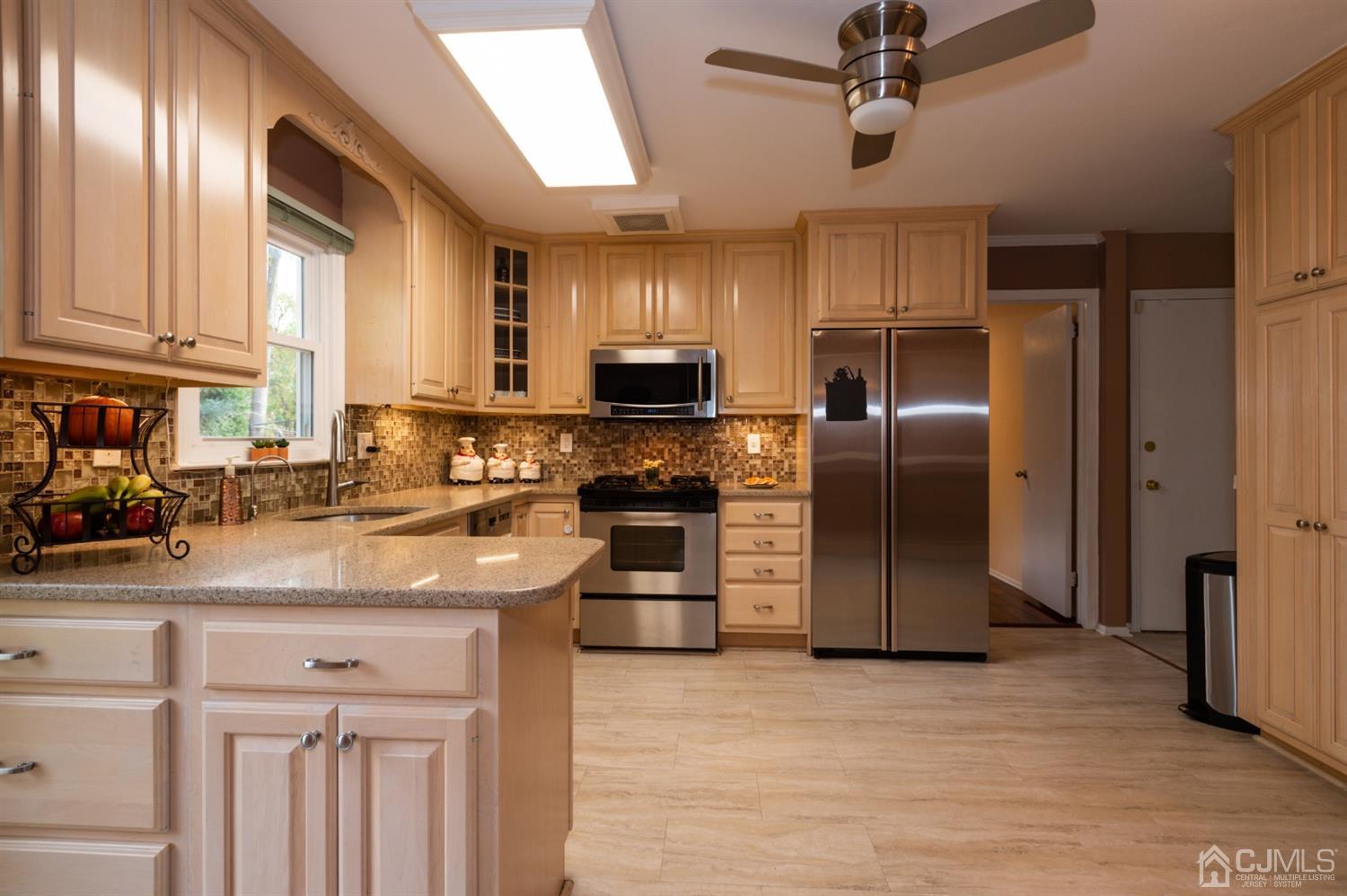 37 Lynnwood Road Edison, NJ 08820 - Photo 5 of 20 a kitchen with stainless steel appliances granite countertop a refrigerator a stove and a sink with wooden floor