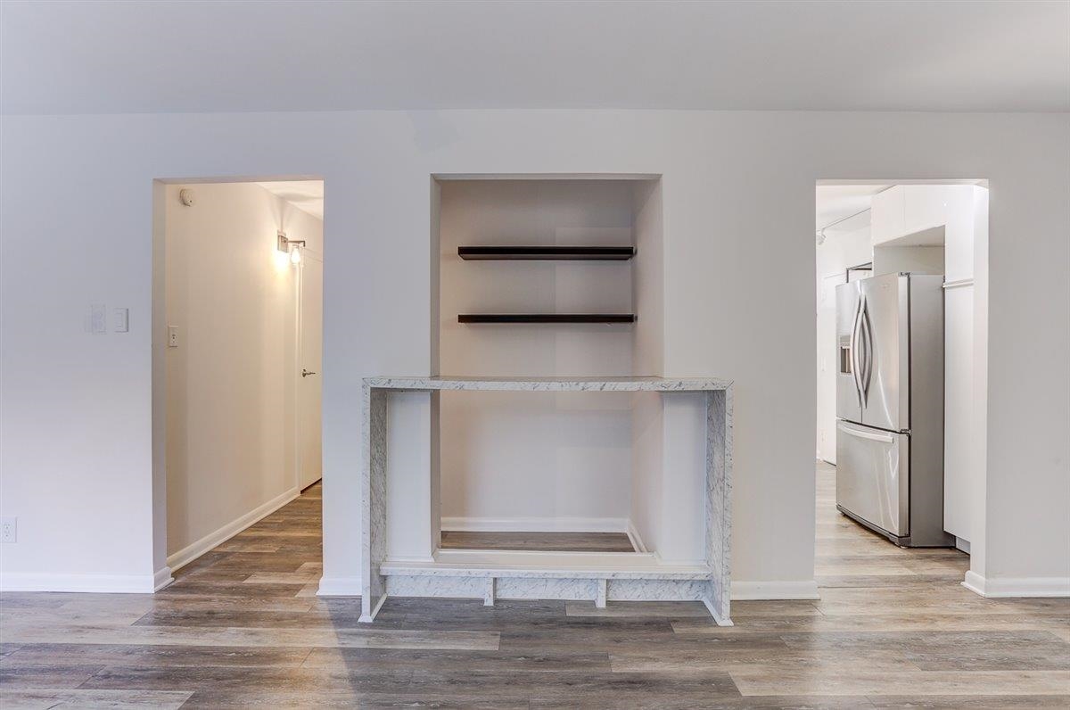 232 South Highland Street, Unit 409 Memphis, TN 38111 - Photo 18 of 39 a view of an empty room with wooden floor and kitchen view