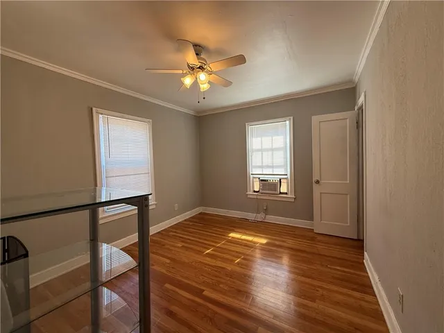 a view of an empty room with a window and wooden floor