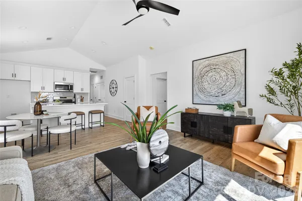 a living room with furniture kitchen view and a window