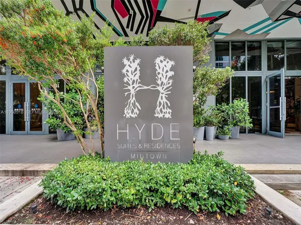 a sign that is sitting in front of a brick house