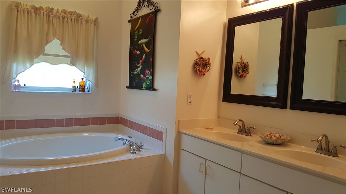 2160 Gardner Road Alva, FL 33920 - Photo 9 of 21 a bathroom with a tub sink and mirror