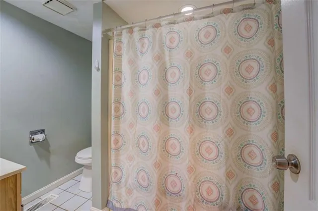 a bathroom with a toilet and shower curtain