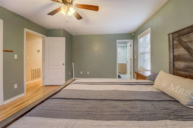a view of a bedroom with wooden floor and a ceiling fan