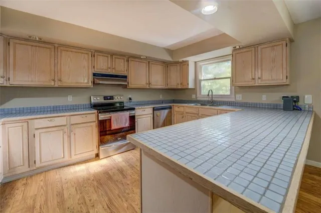 a kitchen with a sink stove and cabinets