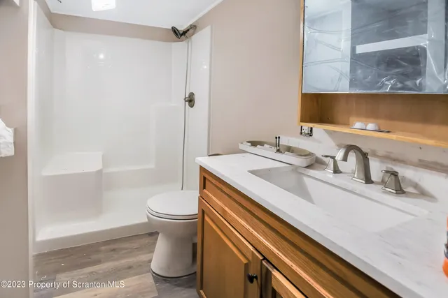 a bathroom with a sink a toilet and shower