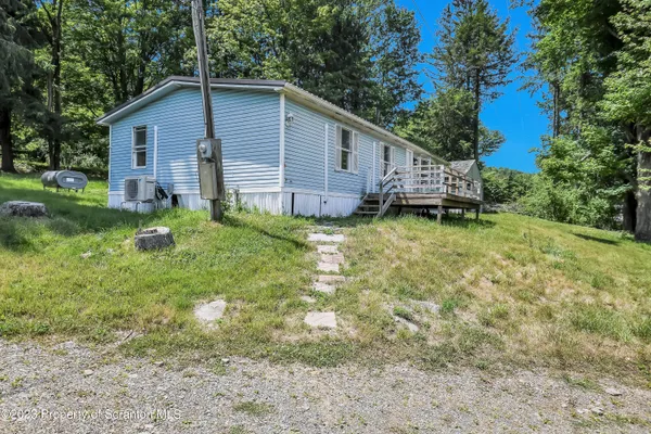 a backyard of a house with wooden deck and tree