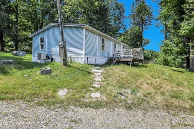 a backyard of a house with wooden deck and tree