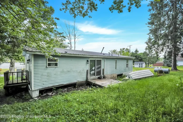 a view of a chair and table in back yard of the house