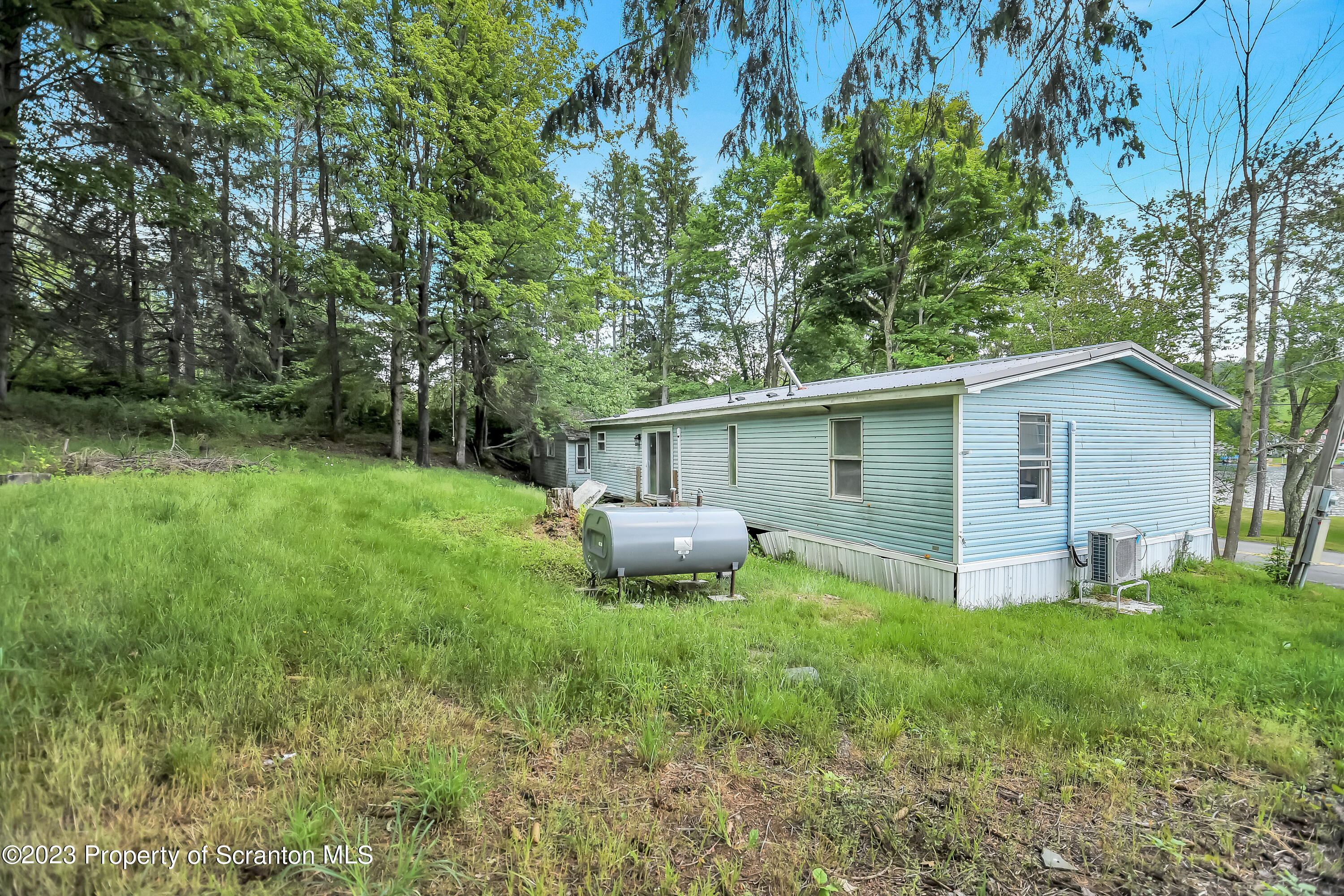 11715 Forest Lake Road Montrose, PA 18801 - Photo 6 of 40 a backyard of a house with lawn chairs plants and tree