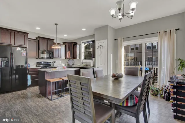 a view of kitchen with refrigerator dining table and chairs