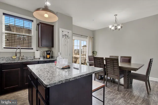a kitchen with granite countertop sink stove and dining table