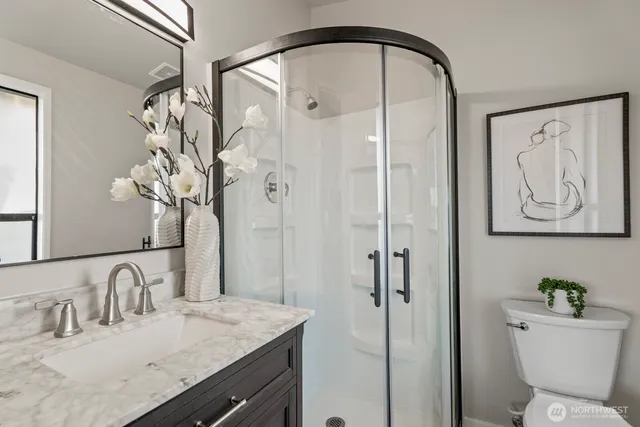 a bathroom with a granite countertop sink a toilet and shower