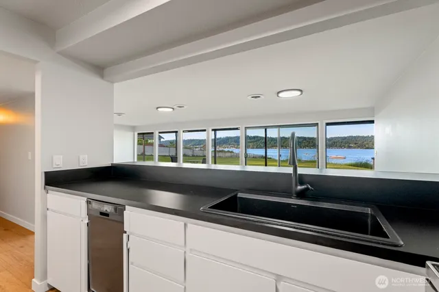 a kitchen with granite countertop a sink and a stove