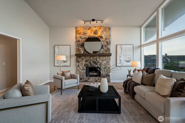 a living room with furniture a fireplace and a large window