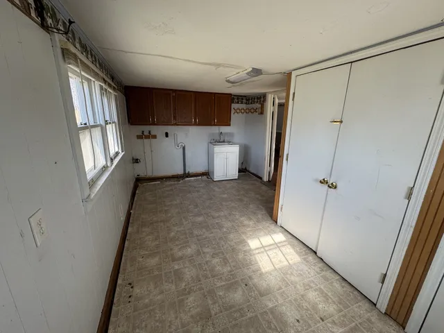 a view of a kitchen with a refrigerator and white cabinets