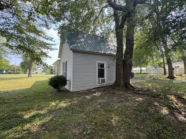 a view of a house with backyard and tree