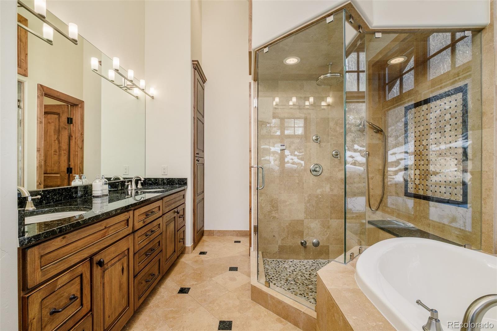 2417 Garmisch Drive, Unit B Vail, CO 81657 - Photo 24 of 43 a bathroom with a granite countertop tub sink a mirror a shower and vanity