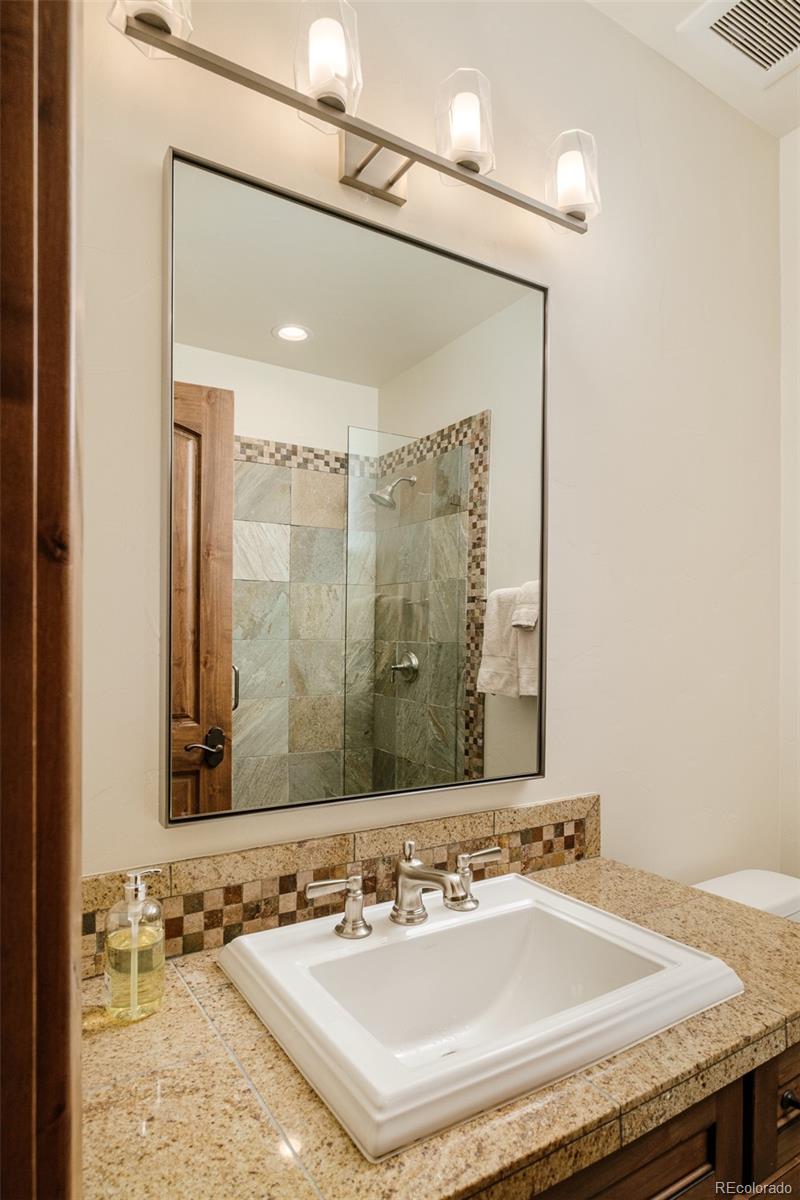2417 Garmisch Drive, Unit B Vail, CO 81657 - Photo 31 of 43 a bathroom with a granite countertop sink and a mirror