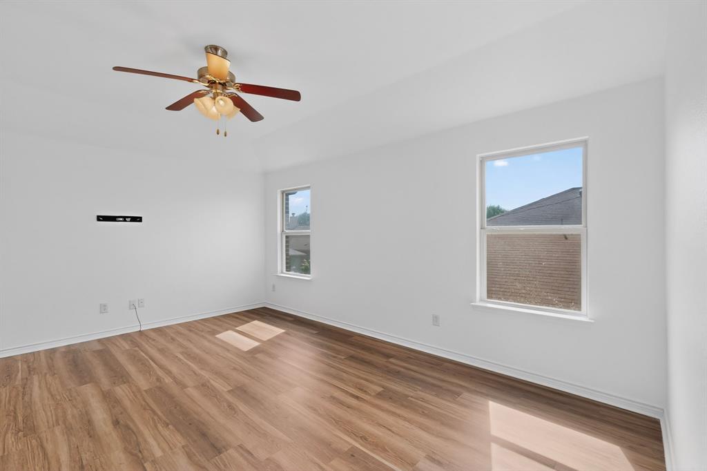 426 Harding Lane Lavon, TX 75166 - Photo 32 of 40 Spacious room featuring wood-finish flooring, white walls, and a ceiling fan with integrated lighting