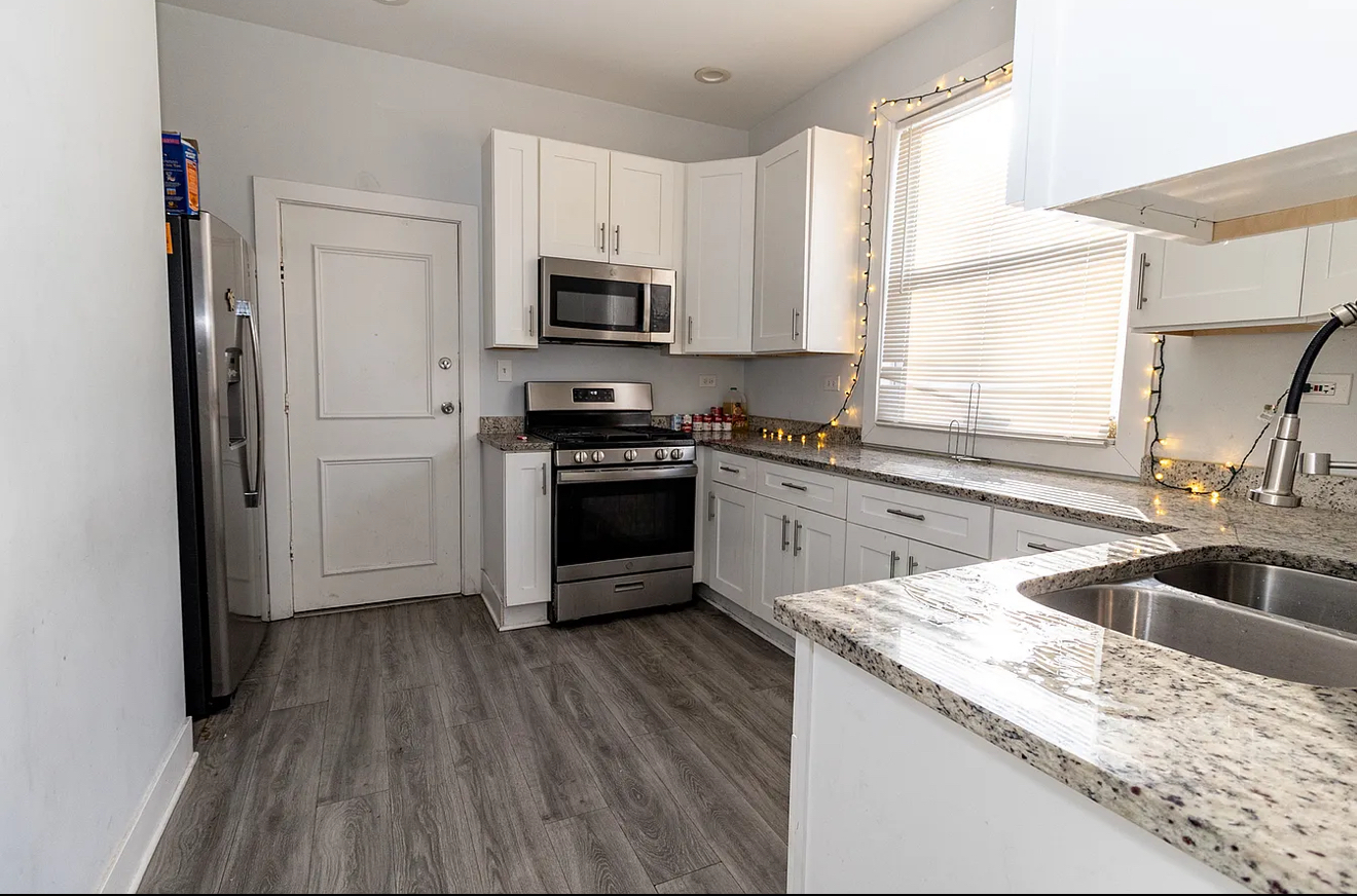 5523 West Huron Street Chicago, IL 60644 - Photo 2 of 10 a kitchen with a sink stove top oven and refrigerator