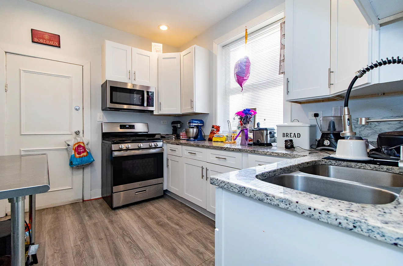 5523 West Huron Street Chicago, IL 60644 - Photo 6 of 10 a kitchen with granite countertop a sink dishwasher and a stove with wooden floor