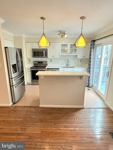 a kitchen with stainless steel appliances granite countertop a sink a stove and a wooden floor