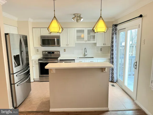 a kitchen with stainless steel appliances a stove a refrigerator and a sink