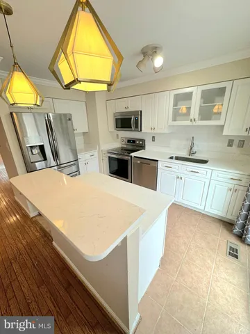 a kitchen with stainless steel appliances a stove a sink and a refrigerator