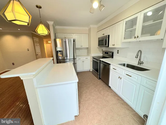 a kitchen with a stove a sink a refrigerator cabinets and a window