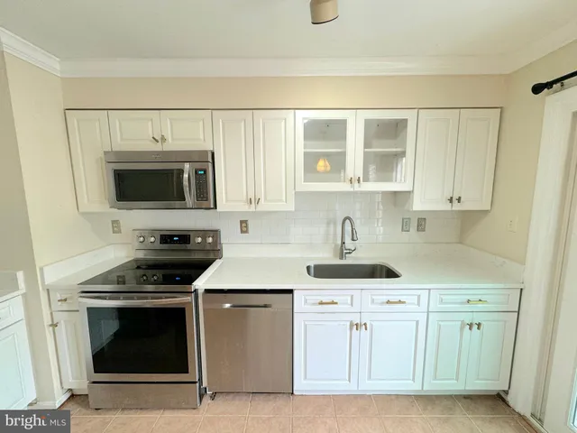 a kitchen with stainless steel appliances a stove a sink and a microwave