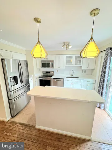 a kitchen with stainless steel appliances granite countertop a sink a stove and a wooden floors
