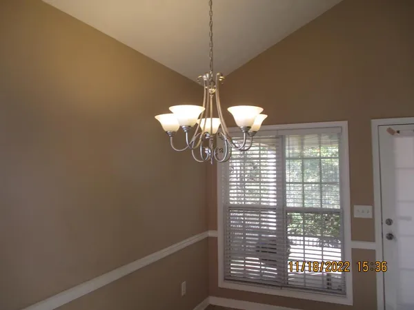 a view of a room with a chandelier fan and wooden floor