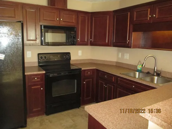 a kitchen with granite countertop a sink stainless steel appliances and cabinets