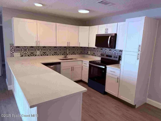 a kitchen with stainless steel appliances a sink stove and refrigerator